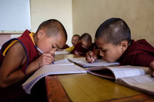 Young students in class learning Tibetan grammar and modern subjects